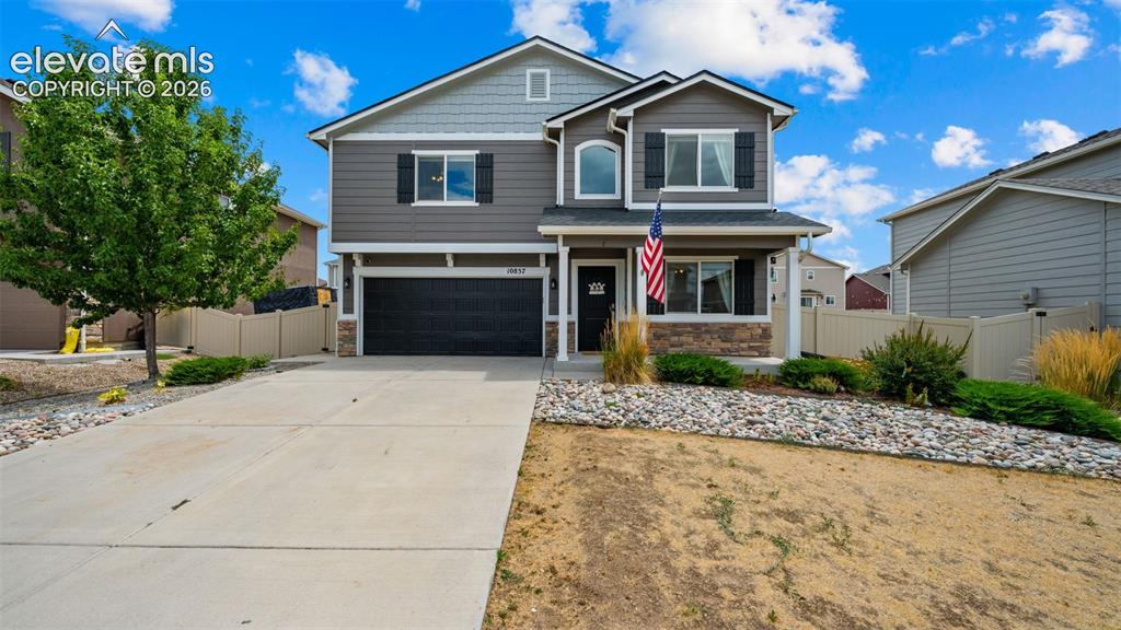 Image 1 of 41: Two-story residence featuring a covered front porch, stone accents, and dar