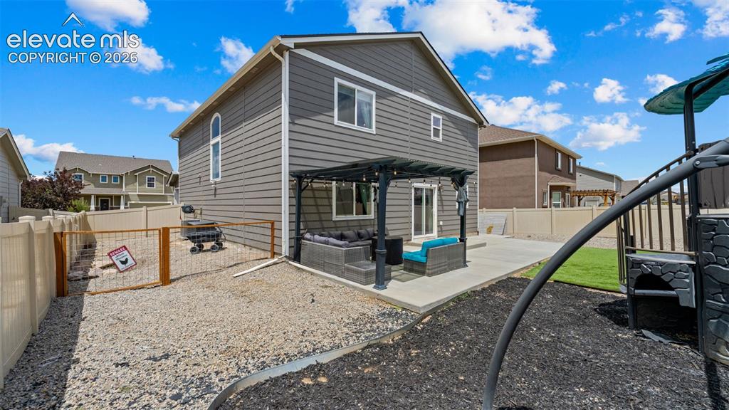 Image 17 of 41: Rear exterior featuring gray horizontal siding, a concrete patio, a dark pe