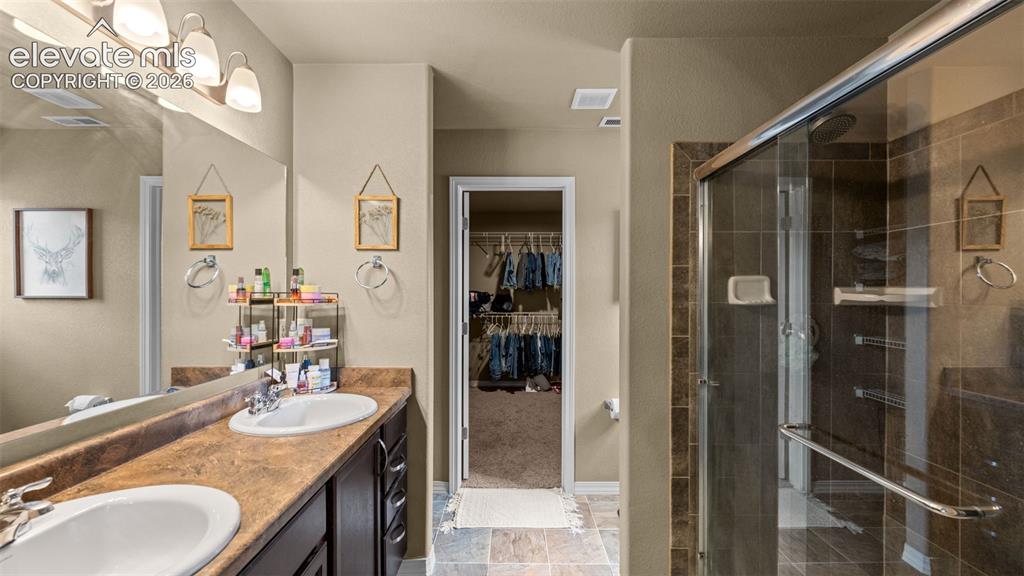 Image 26 of 41: Bathroom featuring a double vanity with integrated sinks, a sliding glass s