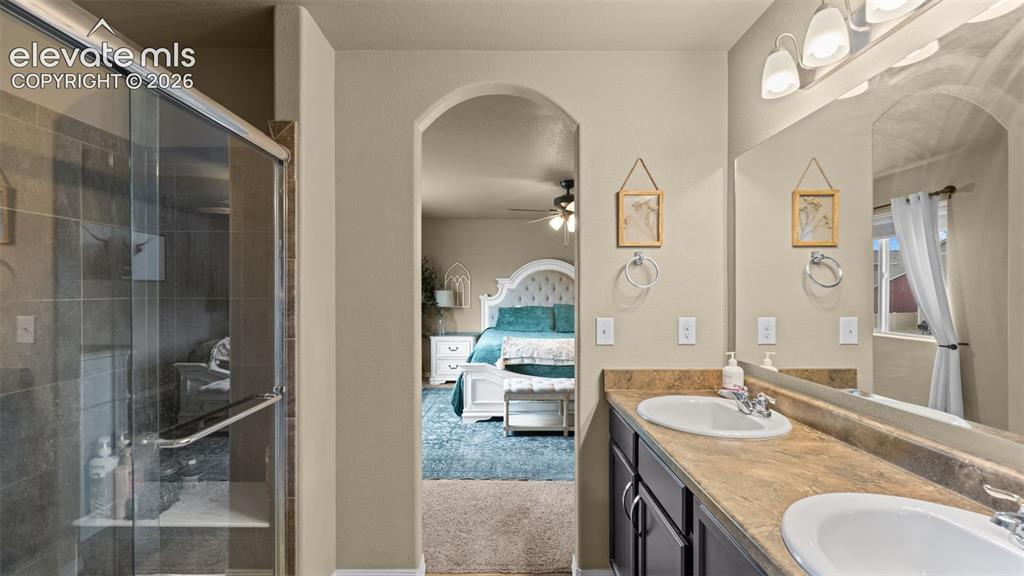 Image 28 of 41: Bathroom featuring a dual-sink vanity with a laminate countertop, an expans