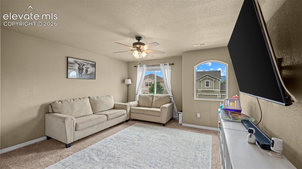 Image 29 of 41: Carpeted room featuring a ceiling fan with integrated lighting, a large arc