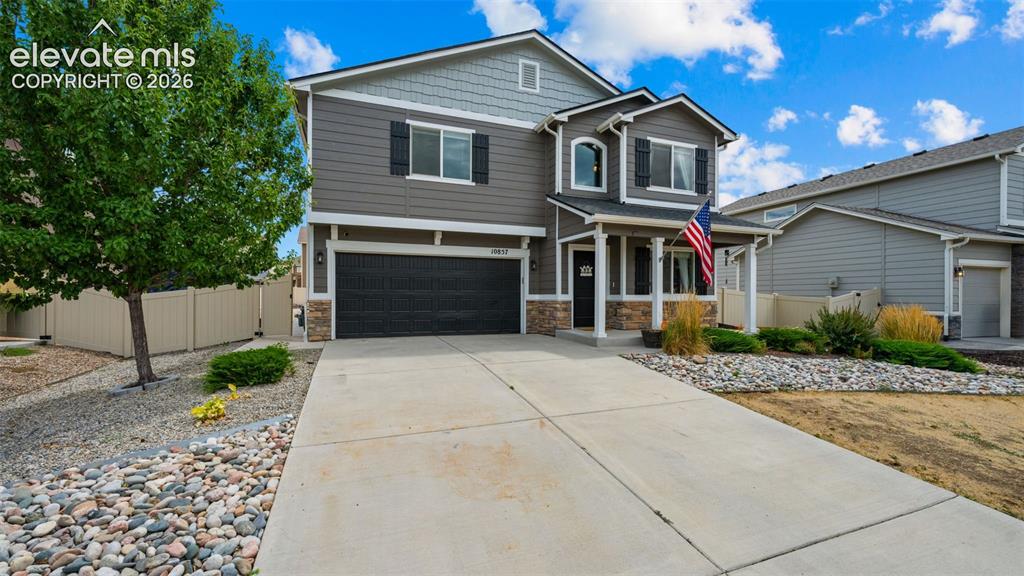Image 3 of 41: Two-story residence featuring a covered front porch, stone and siding exter