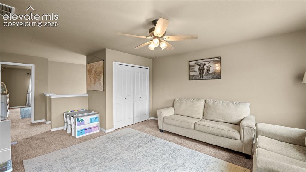 Image 30 of 41: Carpeted interior space featuring a ceiling fan with integrated lighting, b