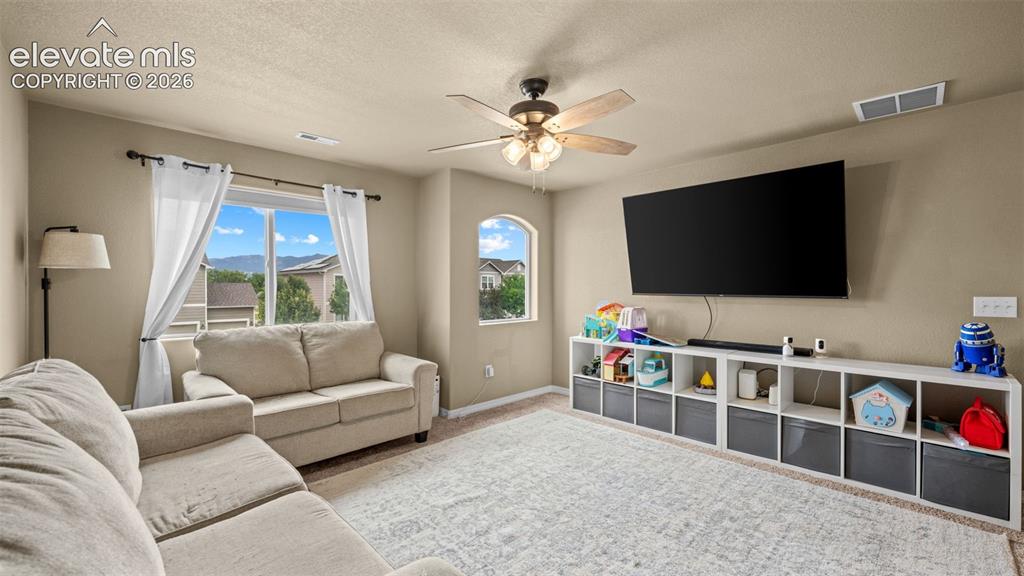 Image 31 of 41: Spacious bonus room featuring a ceiling fan, dual windows, and built-in she