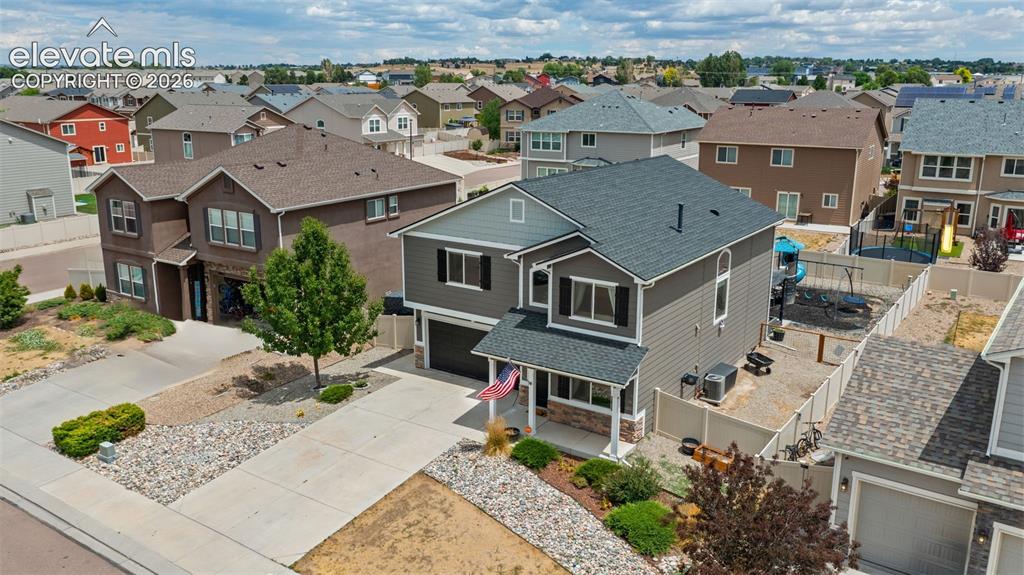 Image 34 of 41: Two-story residence featuring a gray exterior with white trim accents and d