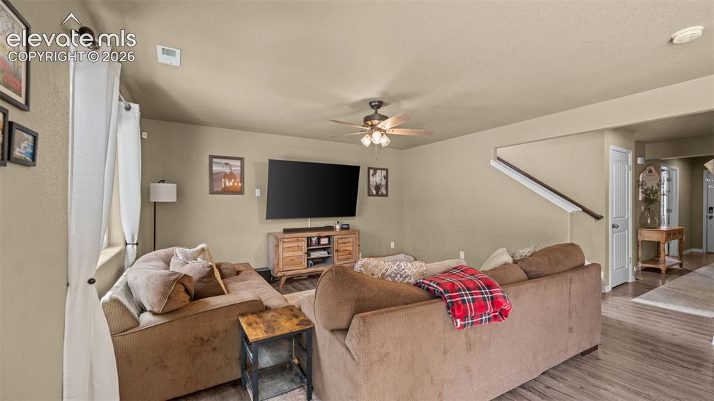 Image 8 of 41: Spacious living area featuring wood-finish flooring, neutral wall tones, an
