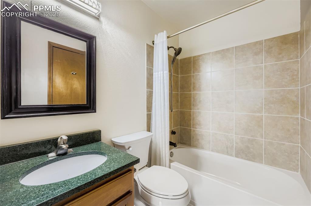 Image 11 of 45: Bathroom featuring shower / bath combination with curtain and vanity