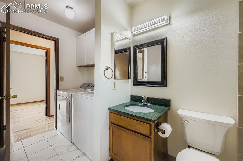 Image 12 of 45: Bathroom with vanity and washer and clothes dryer