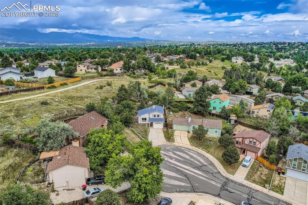Image 44 of 45: Aerial view of residential area featuring a mountainous background