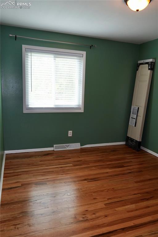 Image 4 of 23: Spare room featuring baseboards and wood finished floors