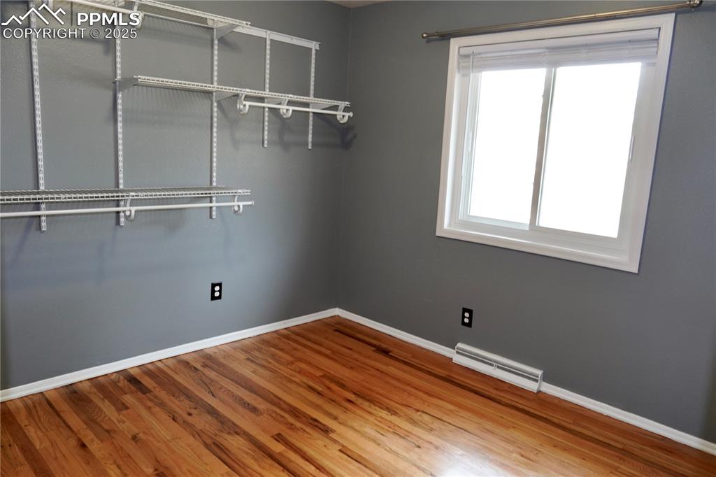 Image 6 of 23: Walk in closet with wood finished floors