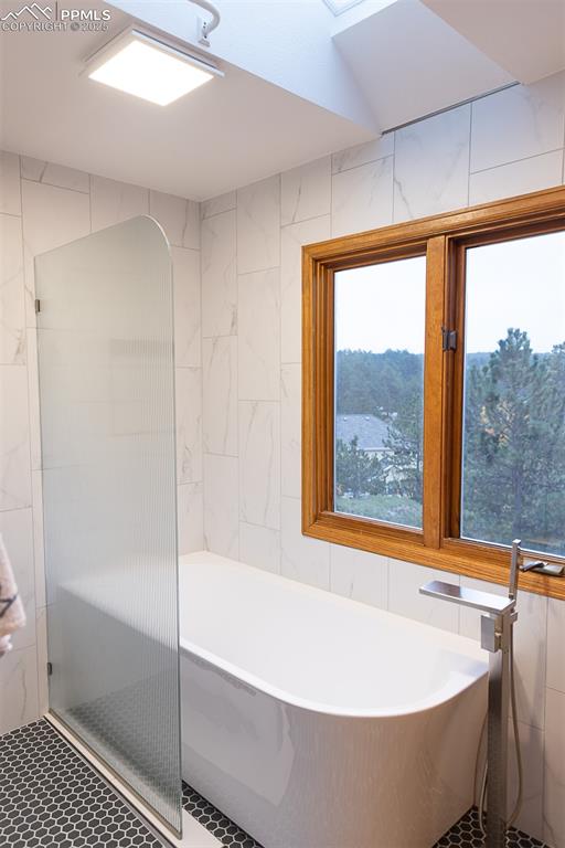Image 42 of 47: Freestanding new tub in primary bathroom.