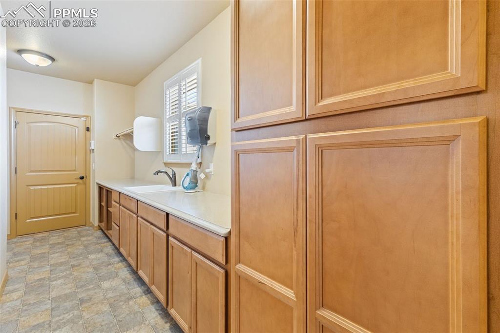 Image 20 of 50: Laundry with sink and storage