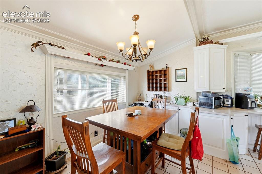 Image 13 of 35: Kitchen area with white cabinetry, light-toned countertops, and a bay windo