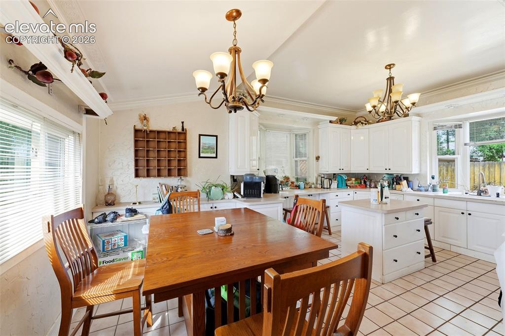 Image 14 of 35: White cabinetry with dark hardware, recessed lighting, tile flooring, and a
