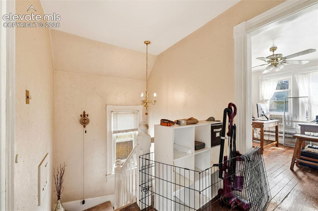 Image 18 of 35: Hardwood flooring and decorative ceiling fan in the adjacent room