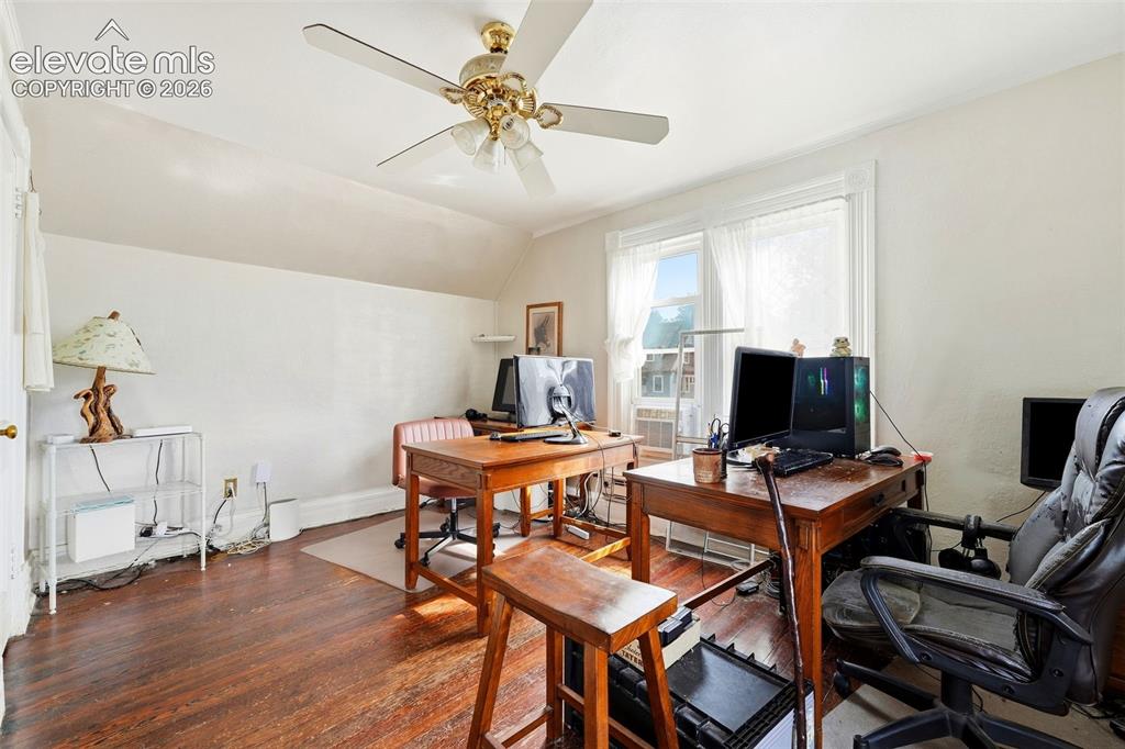 Image 19 of 35: Room with wood-finish flooring, a ceiling fan, and a window with white trim