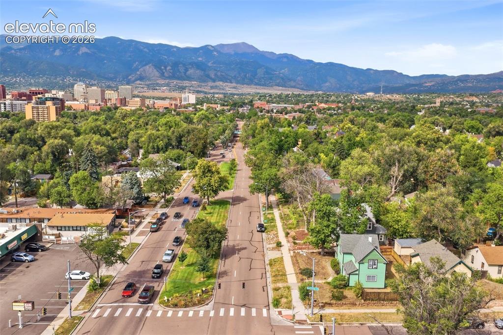 Image 2 of 35: Neighborhood setting with mature trees and mountain backdrop