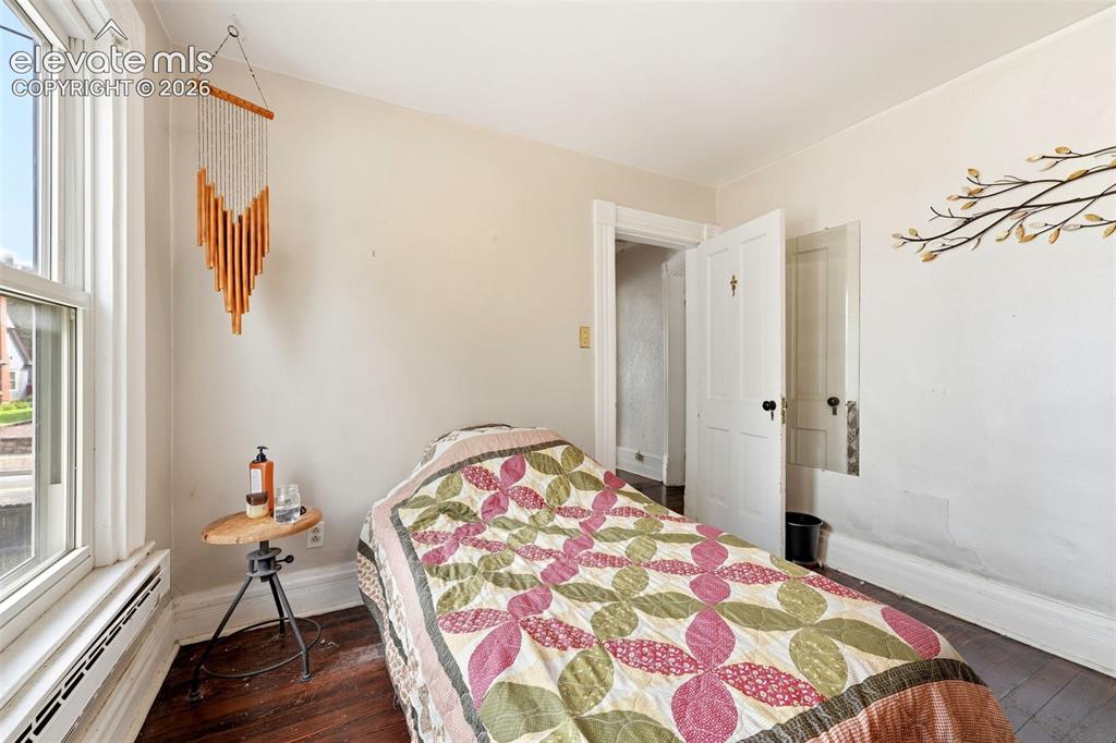 Image 24 of 35: Window with white trim, dark wood-finish flooring, and white painted walls
