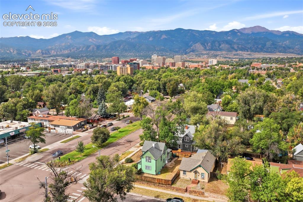 Image 34 of 35: Expansive mountain backdrop, urban skyline, mature trees, residential stree