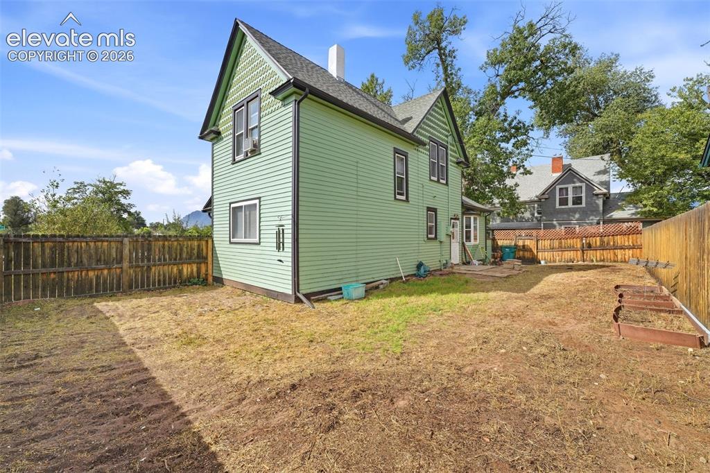 Image 4 of 35: Expansive rear yard featuring wood fencing, a partial concrete patio, and g
