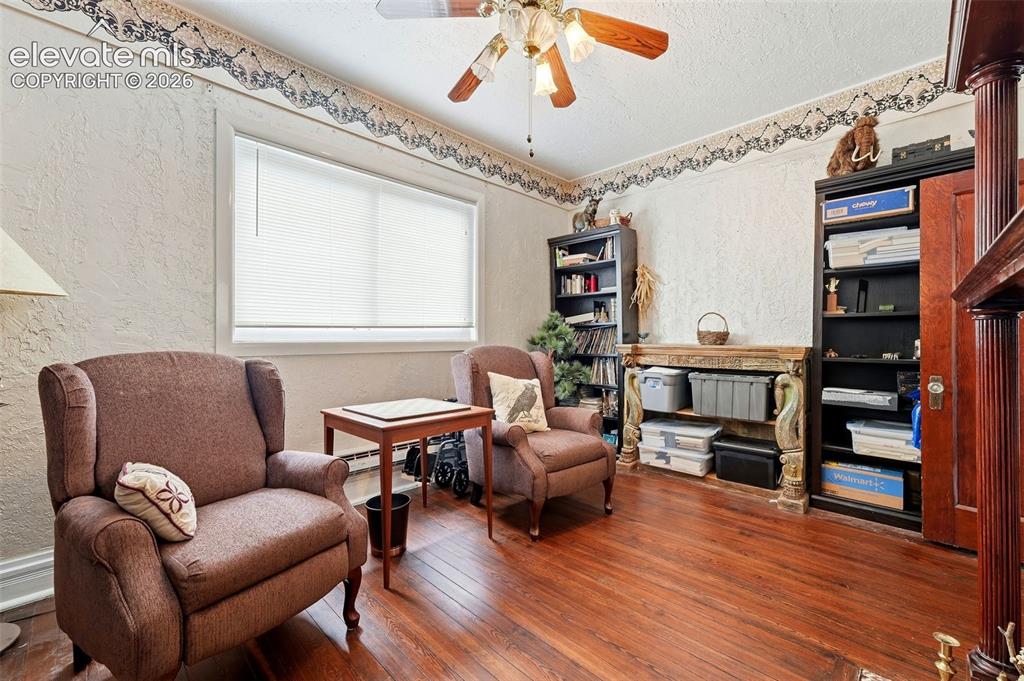 Image 7 of 35: Hardwood flooring, painted walls, ceiling fan, window with blinds, and buil