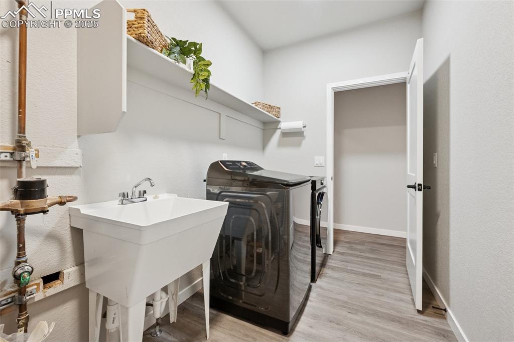 Image 20 of 35: Primary closet leads into laundry room