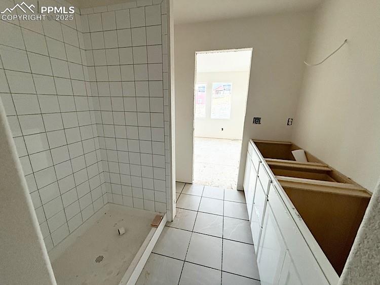 Image 21 of 29: Primary bathroom and walk-in closet with wood shelving and rods! Please, ex