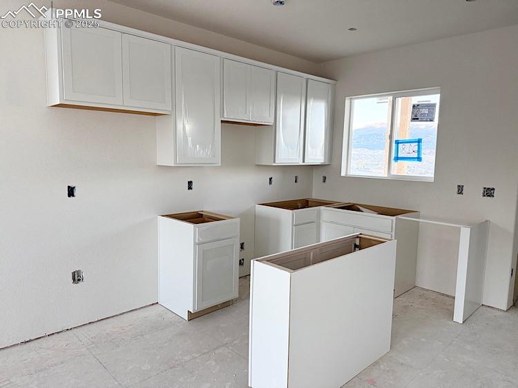 Image 4 of 29: Kitchen with quartz countertops, island, and stainless steel gas range, mic