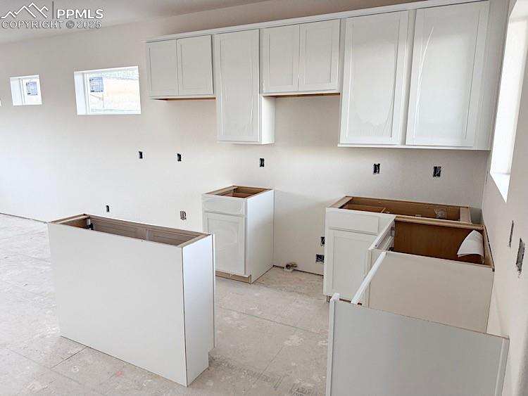 Image 5 of 29: Kitchen with quartz countertops, island, and stainless steel gas range, mic