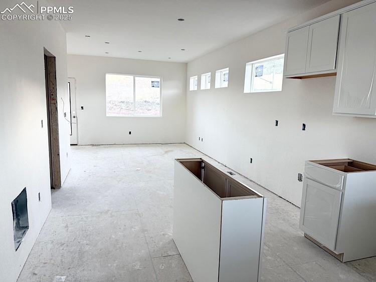 Image 6 of 29: Kitchen with quartz countertops, island, and stainless steel gas range, mic