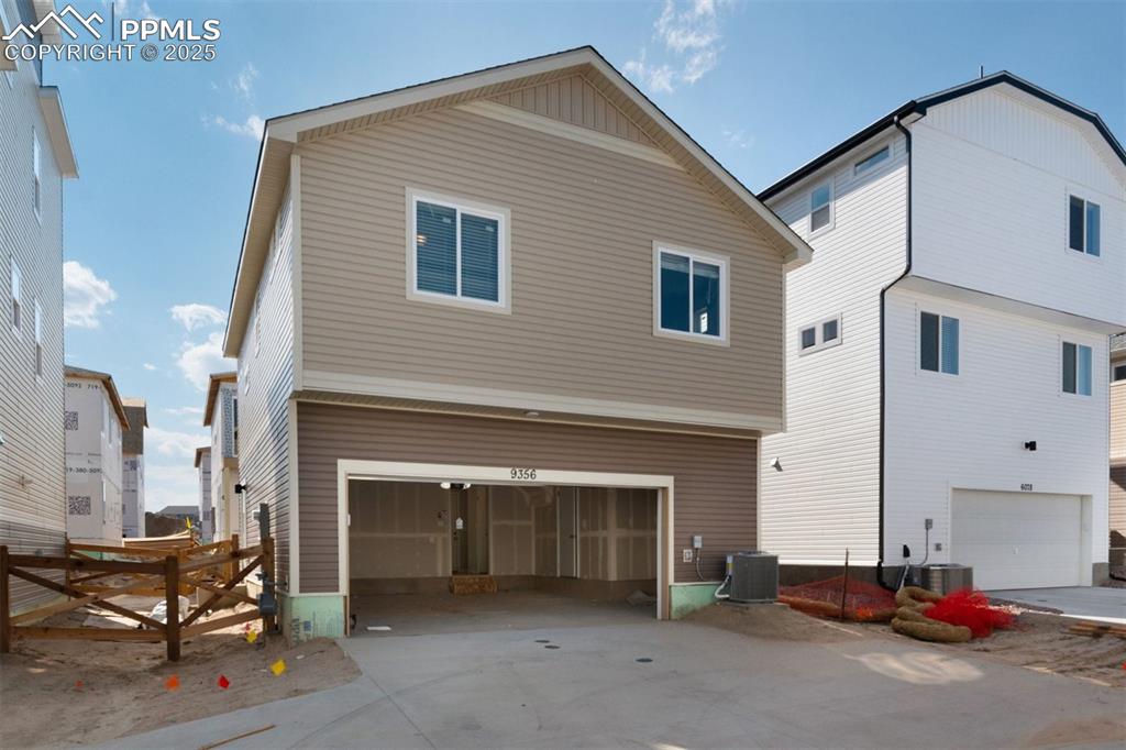 Image 2 of 7: View of side of property with a garage and concrete driveway