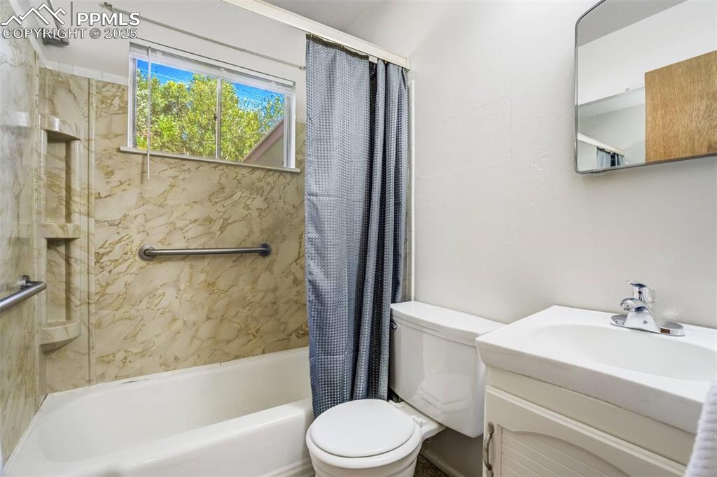 Image 19 of 47: Full bathroom with shower / bath combo with shower curtain and vanity