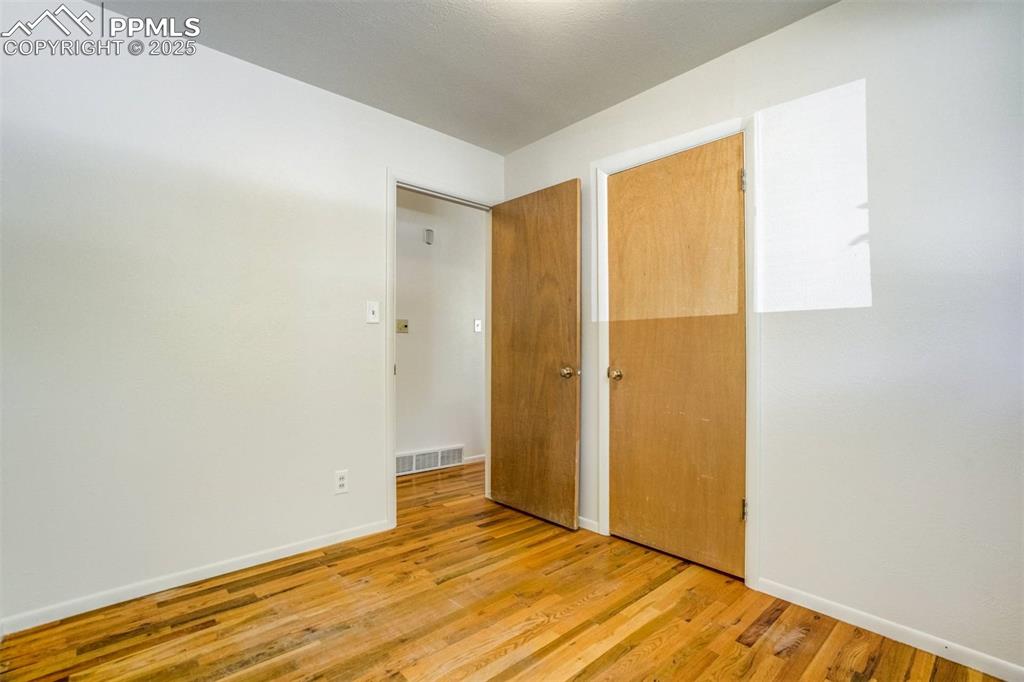 Image 21 of 47: Unfurnished bedroom featuring wood finished floors and a closet