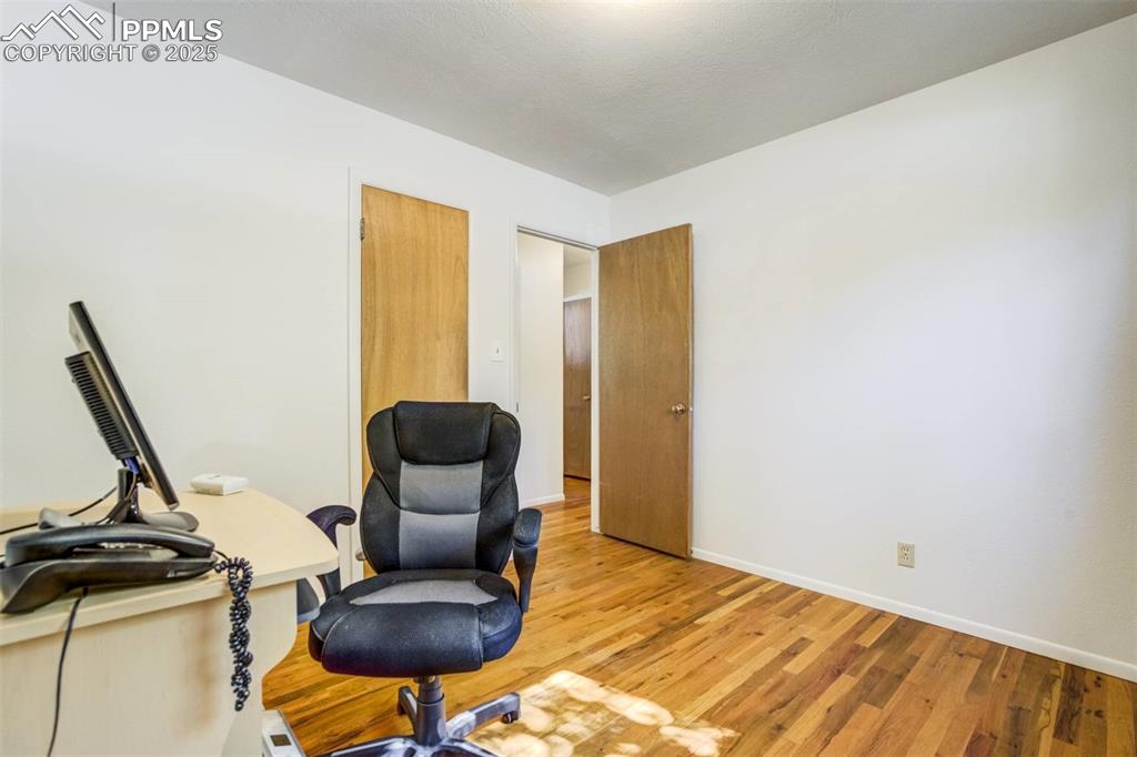 Image 24 of 47: Office area featuring wood finished floors and baseboards