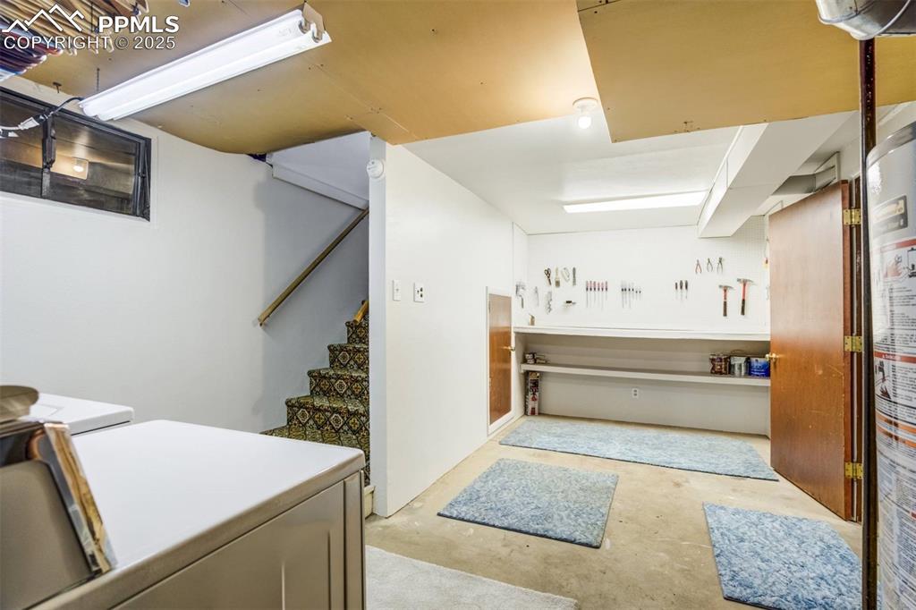 Image 28 of 47: Washroom featuring water heater and washing machine and dryer