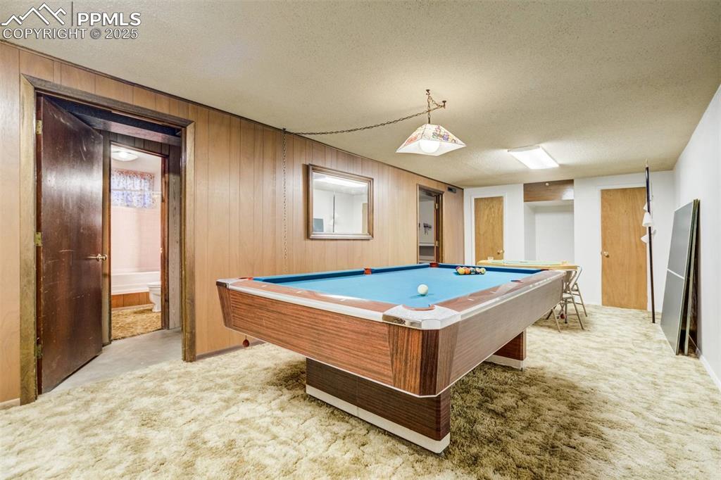 Image 31 of 47: Recreation room featuring light carpet, a textured ceiling, pool table, and