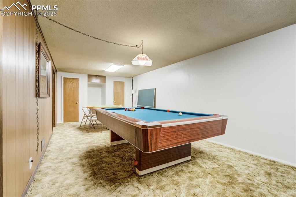 Image 32 of 47: Playroom featuring light colored carpet, a textured ceiling, and pool table
