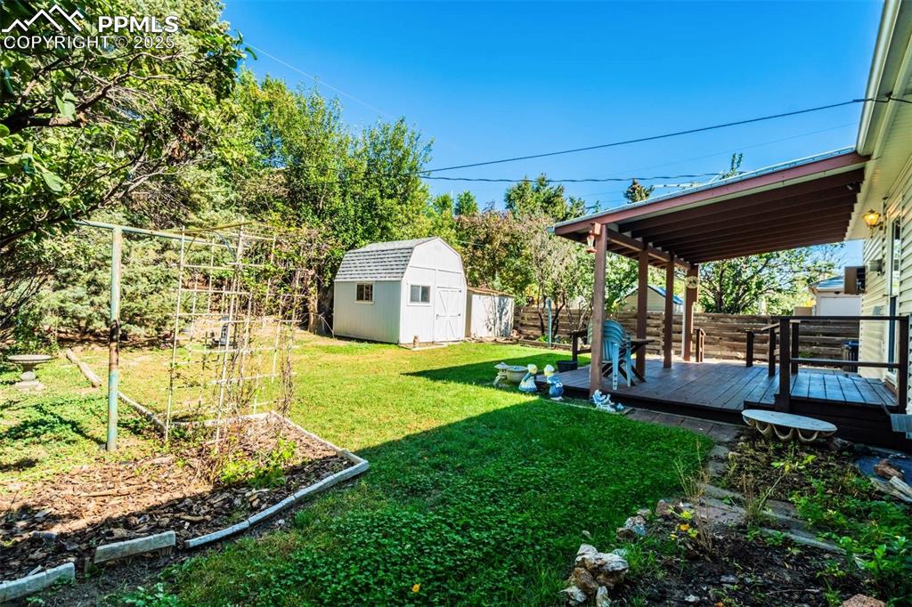 Image 39 of 47: Fenced backyard featuring a wooden deck and a shed