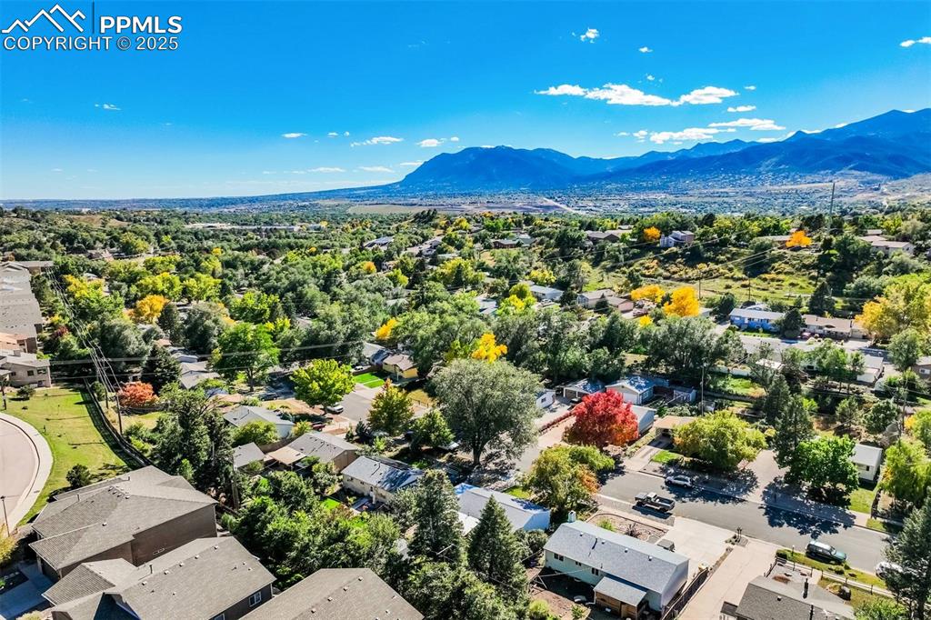 Image 43 of 47: Aerial view of residential area featuring a mountainous background