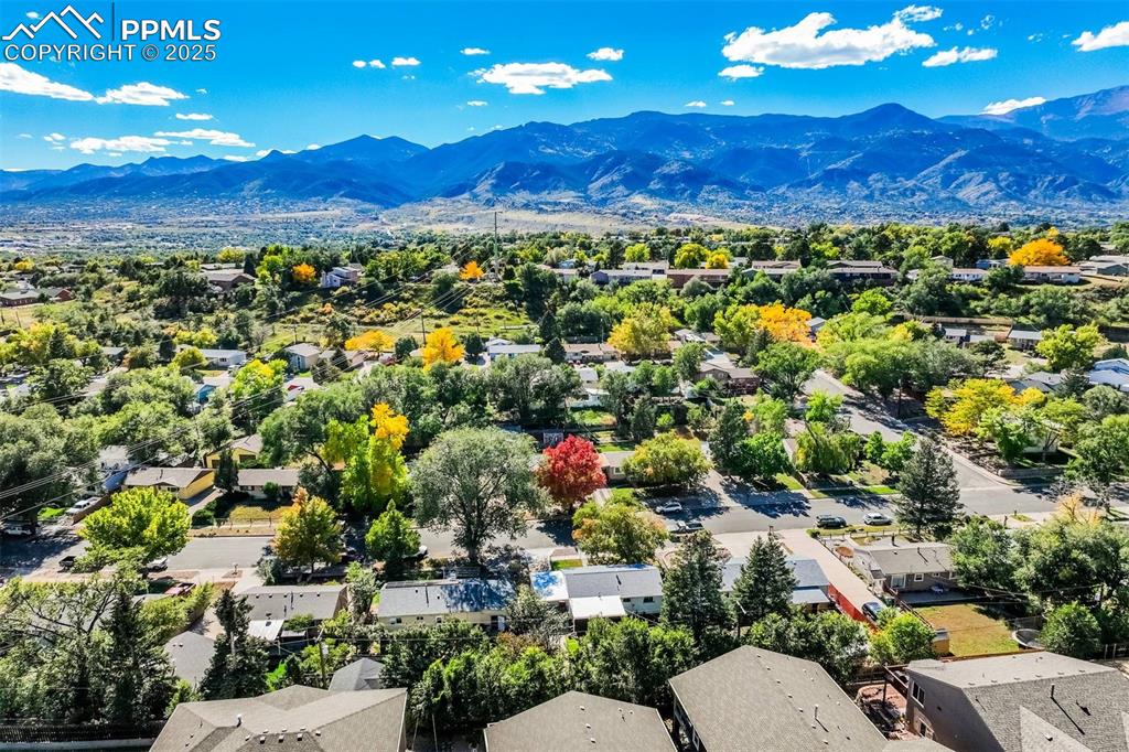 Image 44 of 47: Aerial view of residential area featuring a mountain backdrop