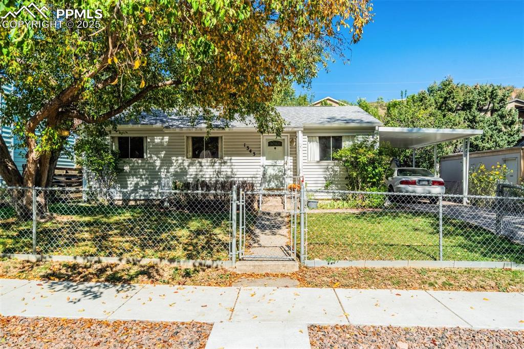 Image 47 of 47: View of front of home with a gate, covered porch, a fenced front yard, a ca