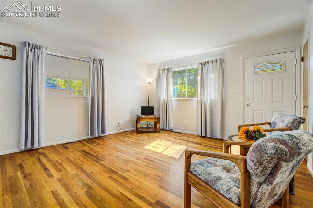 Image 6 of 47: Living area with healthy amount of natural light and wood finished floors