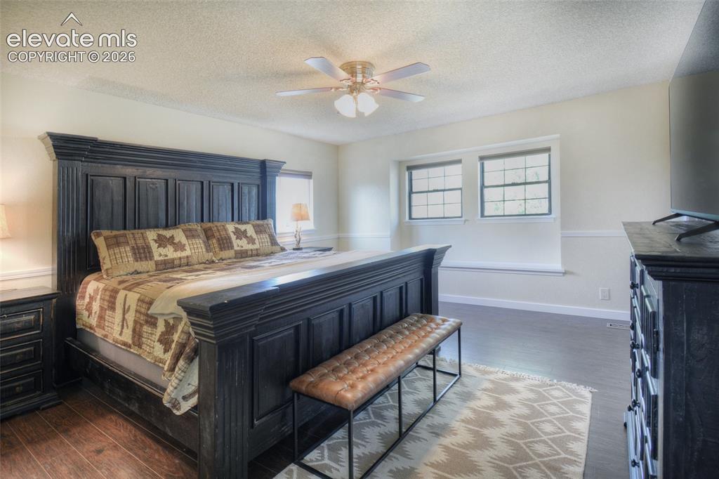 Image 16 of 26: Spacious primary bedroom, LVP flooring, window bench, and adjoining private