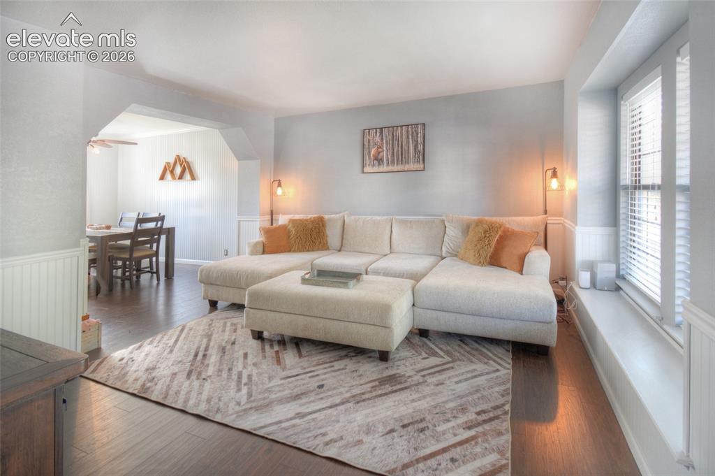 Image 6 of 26: Main level living room flows to the formal dining room and features LVP flo