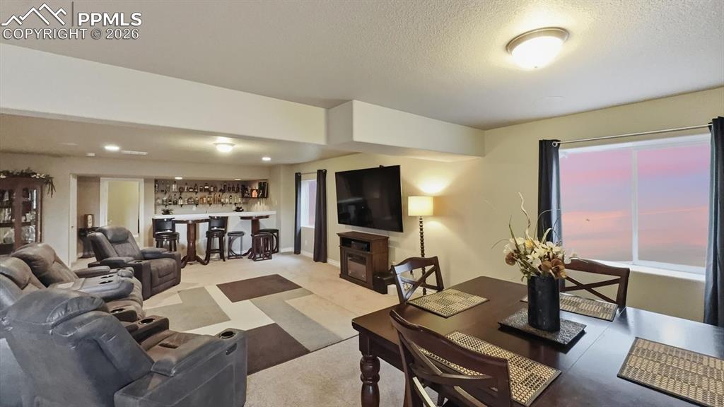 Image 10 of 50: Spacious Basement Family/Rec Room with wet bar, TV area, and dining area.