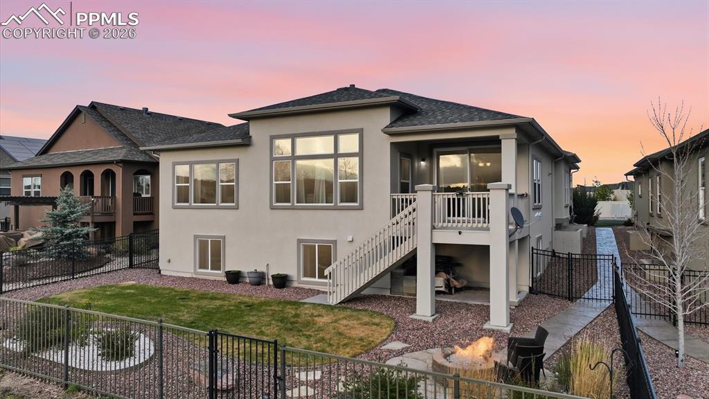 Image 11 of 50: Rear view of home and fenced backyard.