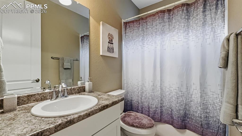 Image 16 of 50: Main Level Full Bathroom with vanity, mirror, and tiled tub/shower.