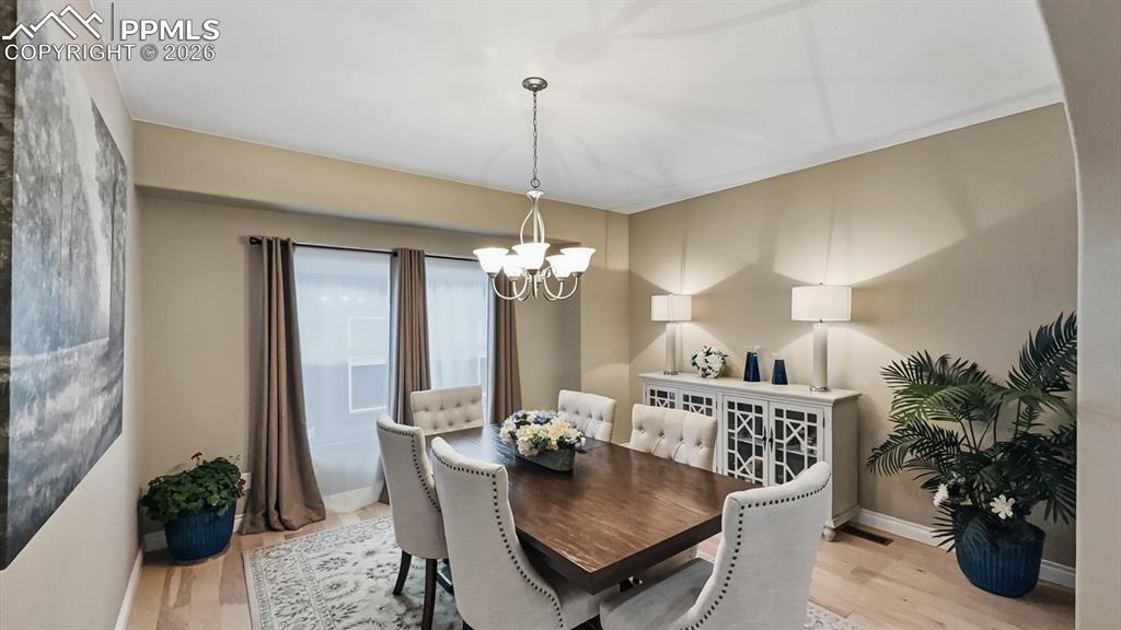 Image 18 of 50: The Formal Dining Room features hardwood floors, and attractive light fixtu