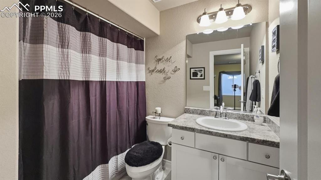 Image 35 of 50: Full Bathroom located off the Bedroom Suite with vanity, mirror, and tiled